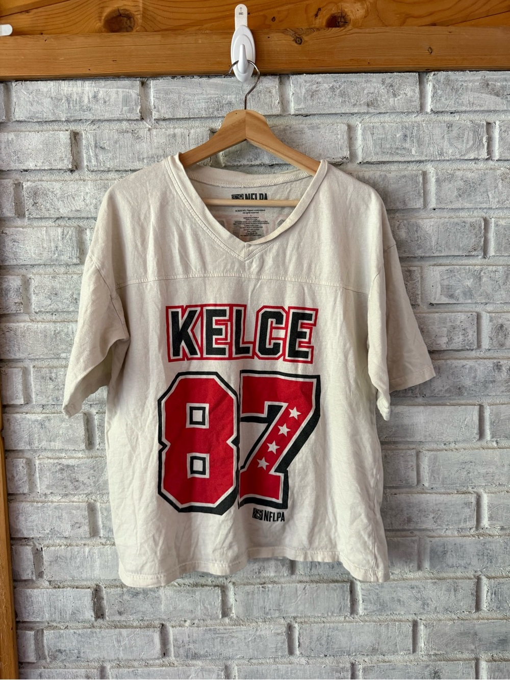 NFLPA Travis Kelce Cream V-Neck Tee with Red & Black Graphic